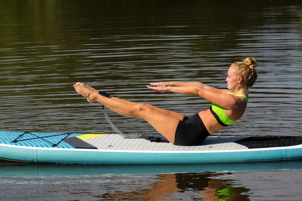 Mulher ativa em pose de ioga em SUP — Fotografia de Stock