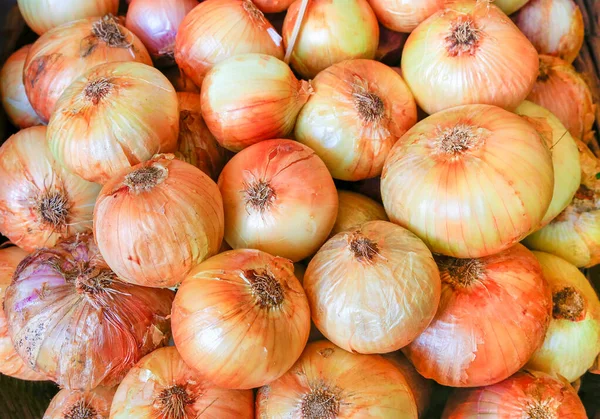 Heap av gul apelsinlök på marknaden — Stockfoto