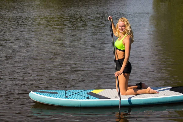 Young woman paddling with SUP on water — Stock Photo, Image