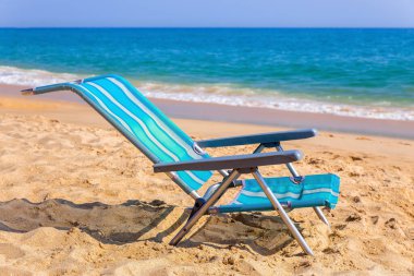 Albufeira sahilinde deniz olan mavi bir sahil sandalyesi.