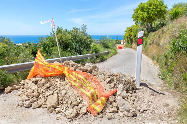 Blockage with stones on coastal road in Greek Kefalonia