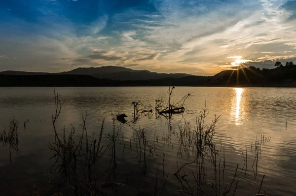 Ununterbrochene Landschaft, die sich im See mit Sonnenstrahlen spiegelt — Stockfoto