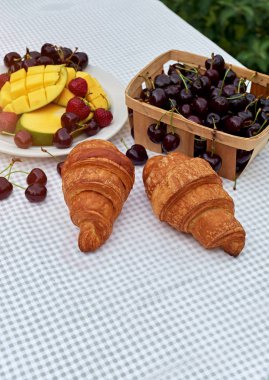 Taze tatlı kiraz, mango ve kruvasan ile meyve salatası masada beyaz arka plan. Düz yatıyordu, konsept kompozisyon brackfast