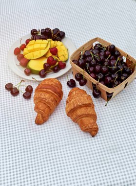 Taze tatlı kiraz, mango ve kruvasan ile meyve salatası masada beyaz arka plan. Düz yatıyordu, konsept kompozisyon brackfast