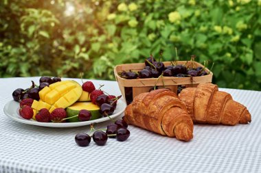 Taze tatlı kiraz, mango ve kruvasan ile meyve salatası masada beyaz arka plan. Düz yatıyordu, konsept kompozisyon brackfast