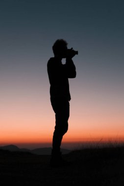 Fotoğrafçı güzel bir gün batımında onun kamera ile ayakta, bu anı yakalamak