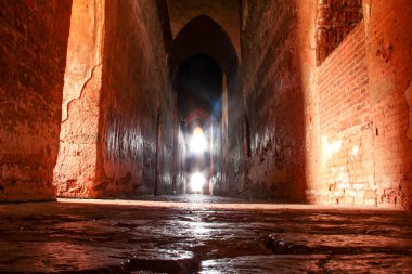 Bagan, Myanmar/Birma'da sonunda parlak pencereleri olan karanlıkta yüksek koridor.