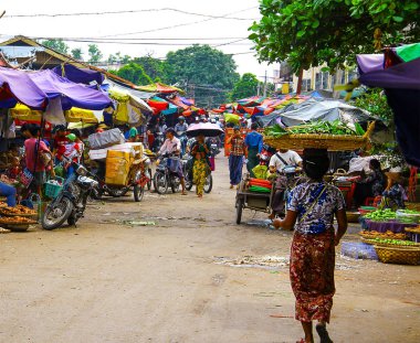 Yangon, Myanmar/Birma'da renkli bir pazarda kafasında büyük bir sepet olan yaşlı kadın.