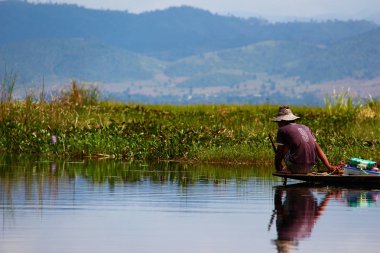 Lake Inle, Myanmar/Birma'da teknesinde şapkasıyla geleneksel balıkçıyı yansıtmak.