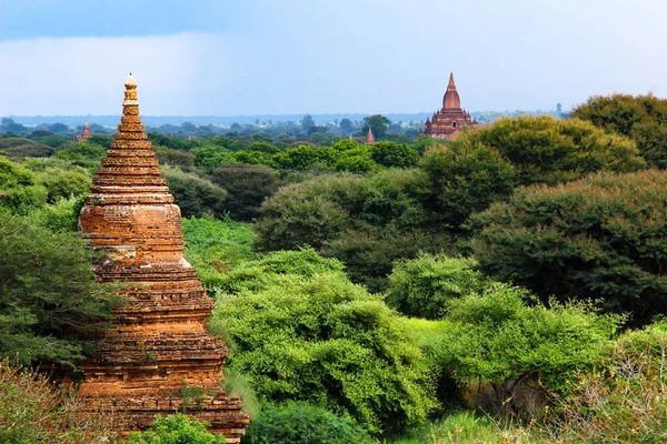 Hilos de viejos templos budistas erosionados entre árboles verdes enBagan, Myanmar / Birmania . —  Fotos de Stock