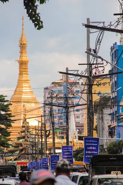 Goldene Pagode am Ende einer Straße mit Strommasten in Yangon, Myanmar / Birma. — Stockfoto