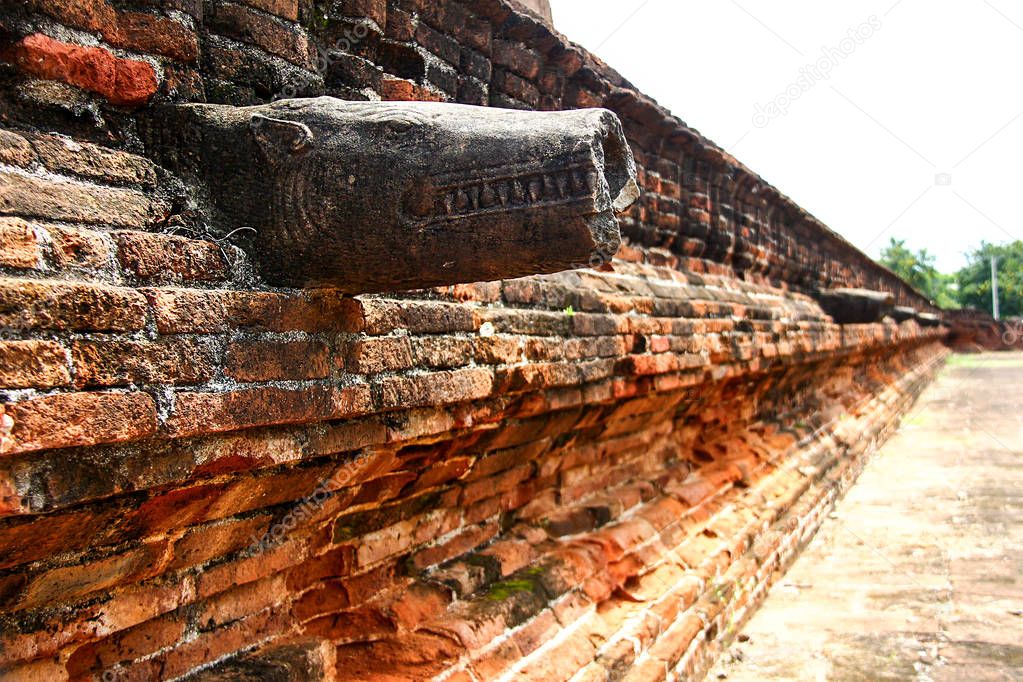 Red brick wall with the broken head of a dragon at the 