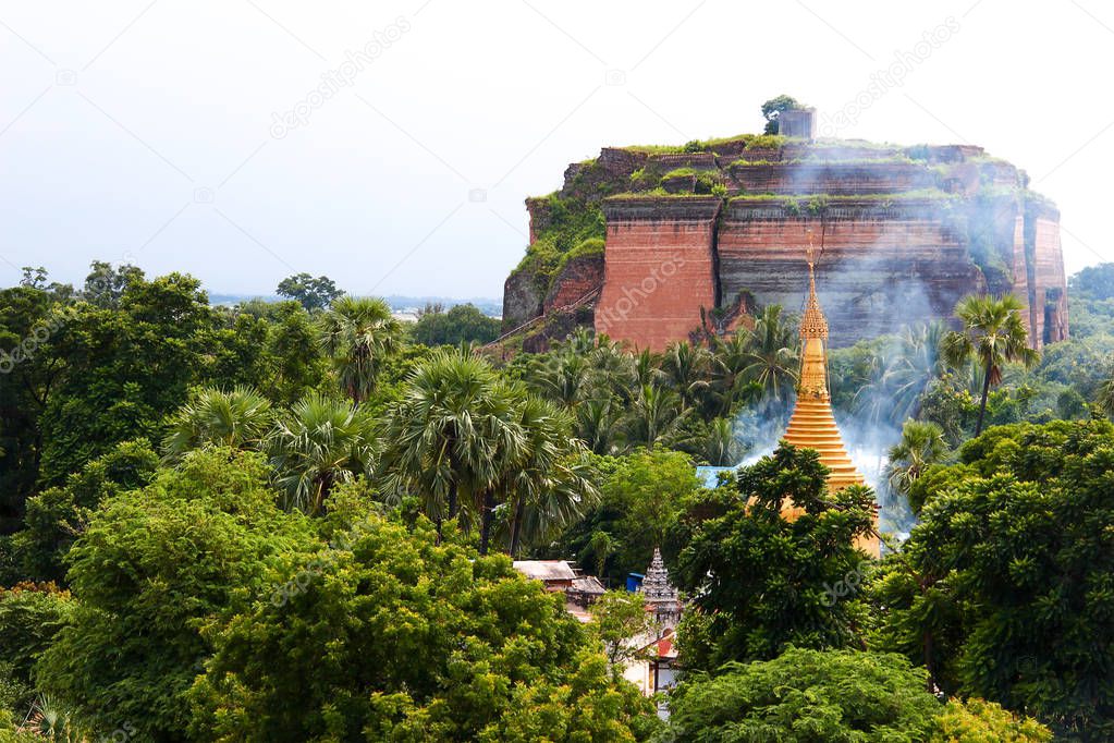 Smoke over golden pagoda in the forest at the 