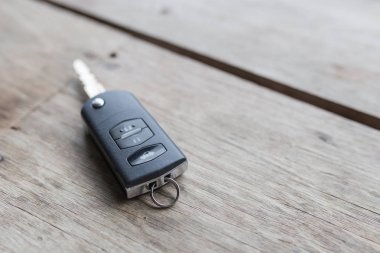 Arabanın anahtarı ahşap arka planda..