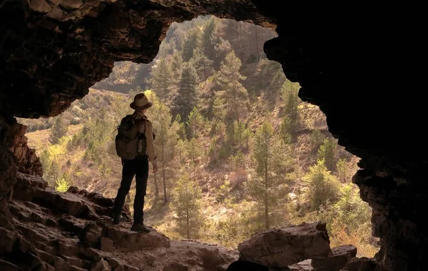 Adventurer Hat Backpack Cave Front Pine Forest — Stock Photo, Image