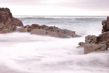 Dalgalar Dayak Kayalar ile bir plajda uzun pozlama fotoğraf