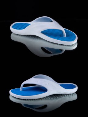 Siyah arka plan üzerinde erkek beyaz ve mavi kauçuk terlik, izole ürün.