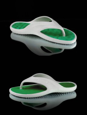 Siyah arka planda erkek beyaz ve yeşil terlikler, izole edilmiş ürün..