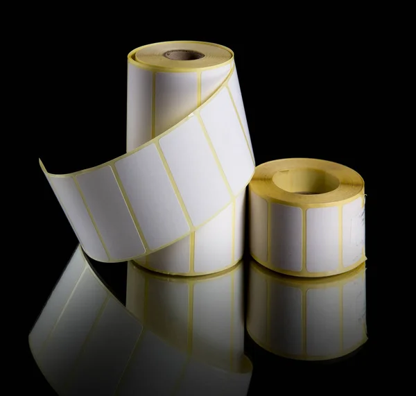 Print labels in rolls isolated on black background.