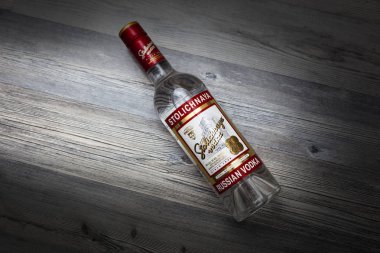 CHISINAU, MOLDOVA - May 21, 2018: A bottle of Stolichnaya vodka on an wooden background. Russian traditional alcoholic beverage, produced in Russia at Cristal enterprises clipart