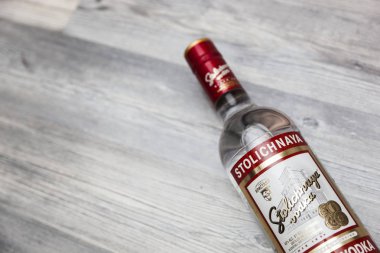 Chisinau, Moldova 18 June 2018: A bottle of Stolichnaya vodka on an wooden background. Russian traditional alcoholic beverage, produced in Russia at Cristal enterprises clipart