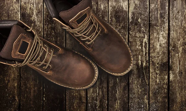 Braune Herrenstiefel, auf einem hölzernen Hintergrund — Stockfoto