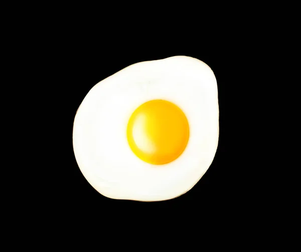 Жареное яйцо на черном фоне — стоковое фото