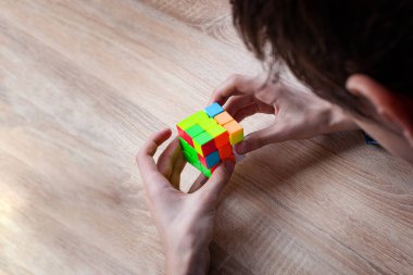 Rubik küpünü tutan ve onunla oynayan genç adamlar