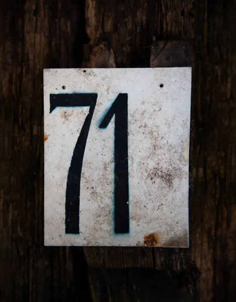 Nummer 12 steht auf einer weißen Metalltafel auf einem Holzrücken — Stockfoto