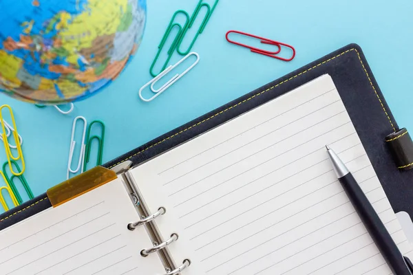 Lederen ringplanner met zwarte pen, wereldbol en kleurrijke clips — Stockfoto
