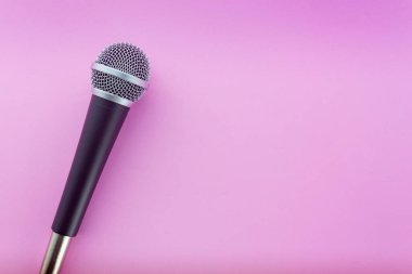 Üst görüntüde pembe arkaplanda mikrofon