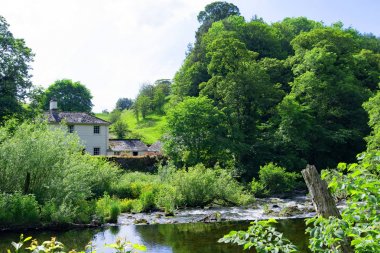 Askham, Penrith, Cumbria, İngiltere'de Lowther Nehri'nin yanında bir kır evi içeren, bir quintessentially İngiliz köy pastoral sahne yakalama.