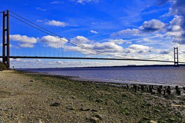 Capturing the famous and magnificent Humber Bridge, in front of a dramatic and atmospheric cloudy background. clipart