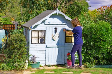 Capturing a mature lady, revisiting her childhood playhouse.