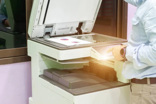 Men press the button of the copier. Man copying paper from Photo