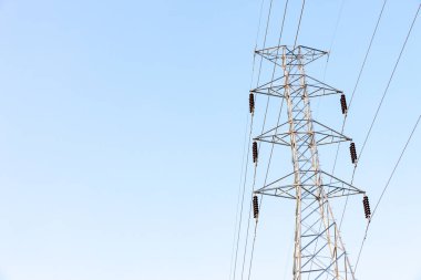 Mavi arka planlı yüksek voltaj kulesi. Yüksek voltaj direği.