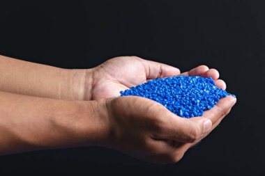 Blue plastic grain, plastic polymer granules,hand hold Polymer pellets, Raw materials for making water pipes, Plastics from petrochemicals and compound extrusion, resin from plant polyethylene. clipart