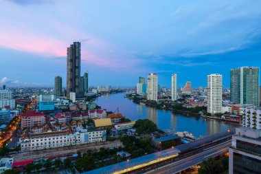 Güneşin doğuşundaki şehir manzarası. Şehir tepede. Nehre bak.
