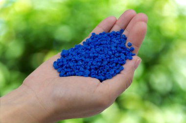 Plastik polimer granüllere yakın çekim. Doğa arka planında Polymer topağı elle tutulur. Polimer plastik. bileşik polimer.