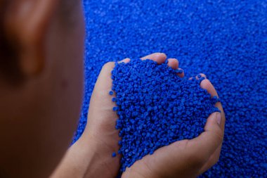 Plastik polimer granüllere yakın çekim. Polymer topaklarıyla el ele tutuşun. Polimer plastik. bileşik polimer.