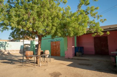 Sudanese village scene in Abri with public drinking water pots clipart