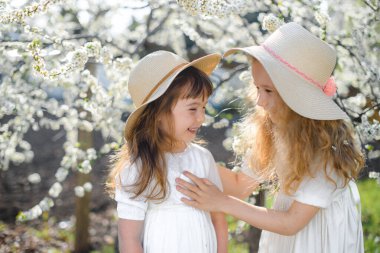 Çiçek açan bahçede gülümseyen kardeşler