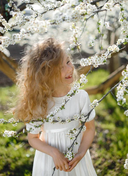 中ブロンド髪笑顔美しいです女の子で開花庭 — ストック写真