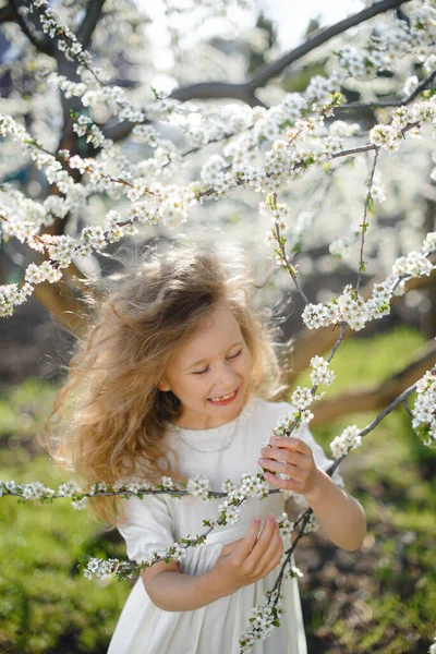 꽃피는 정원에서 아름다운 웃음을 곱슬곱슬 금발의 — 스톡 사진
