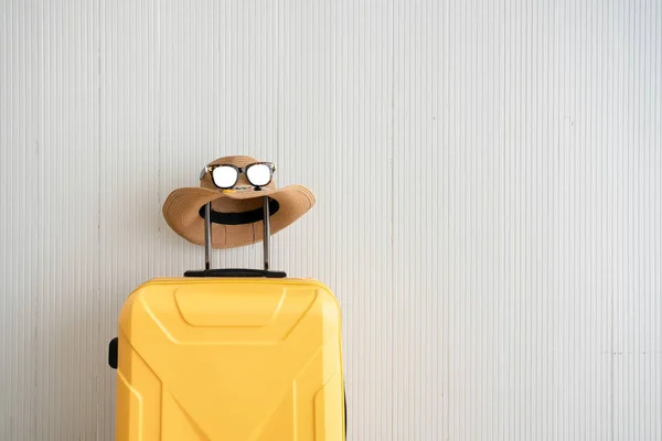 Sarı bavullar tatil seyahati, güneş gözlüğü ve deniz yolculuğu için aksesuarlar.