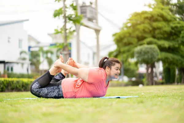 Yeni normal kavram, genç kadın motivasyon egzersizinden ya da bahçede yoga yapmaktan mutlu. Şişko kadının kilo vermek ve sağlıklı yaşam kurmak gibi bir niyeti var..