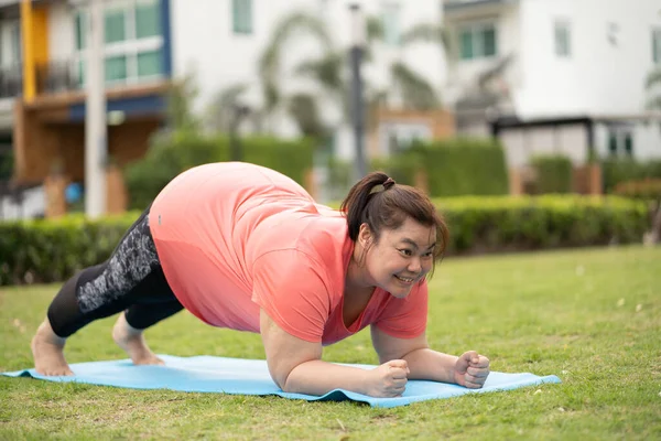 Yeni normal kavram, genç kadın motivasyon egzersizinden ya da bahçede yoga yapmaktan mutlu. Şişko kadının kilo vermek ve sağlıklı yaşam kurmak gibi bir niyeti var..