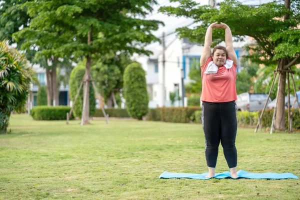 Yeni normal kavram, genç kadın motivasyon egzersizinden ya da bahçede yoga yapmaktan mutlu. Şişko kadının kilo vermek ve sağlıklı yaşam kurmak gibi bir niyeti var..