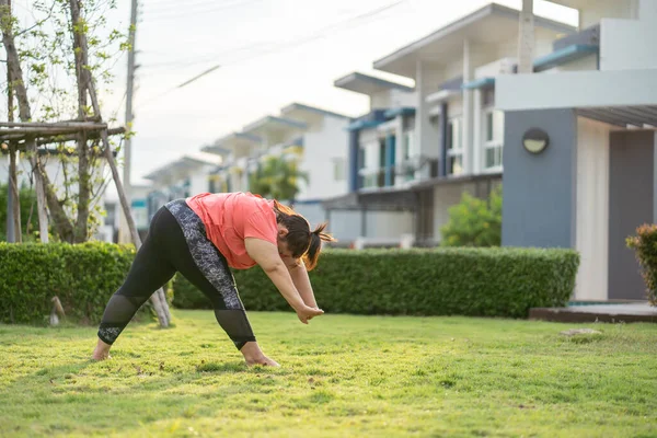 Yeni normal kavram, genç kadın motivasyon egzersizinden ya da bahçede yoga yapmaktan mutlu. Şişko kadının kilo vermek ve sağlıklı yaşam kurmak gibi bir niyeti var..