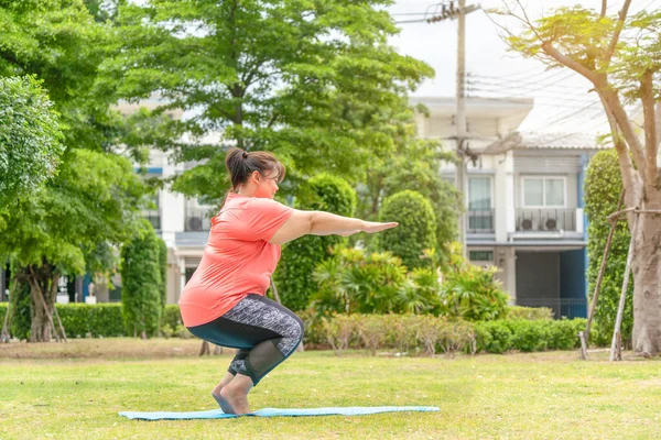 Yeni normal kavram, genç kadın motivasyon egzersizinden ya da bahçede yoga yapmaktan mutlu. Şişko kadının kilo vermek ve sağlıklı yaşam kurmak gibi bir niyeti var..